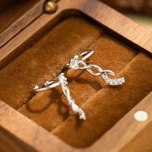 Detailed view of silver crossover ear cuff with sparkling zircons in a wooden jewelry box