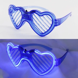 Close-up of blue heart-shaped LED shutter glasses glowing in dark party settings