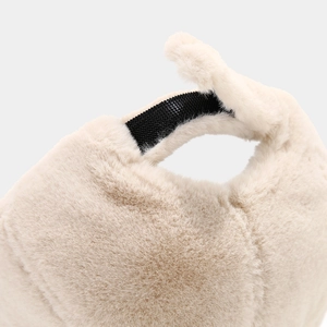 Close-up of soft plush winter hat material with black hook and loop fastener strap