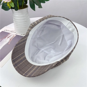 Detail view of plaid beret hat showing internal lining and adjustable white drawstring