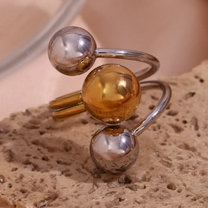 Detail shot of 18K gold and silver triple sphere adjustable ring on a stone