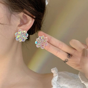 Detail of colorful floral earrings with iridescent finish shown on an ear for size