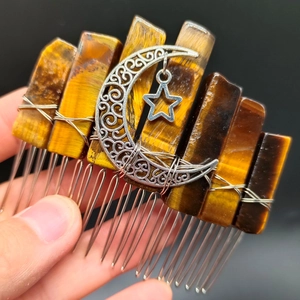 Macro shot of tiger eye crystal hair comb with silver moon and star metal pendants