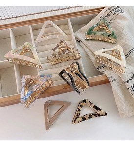Detail of 8 assorted acetate triangle hair claws featuring marble and tortoiseshell patterns