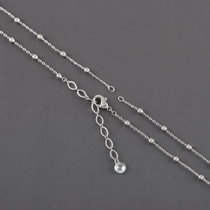 Close-up of silver beaded cross chain with lobster clasp and crystal pendant