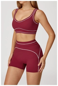 Detail of high-waisted burgundy yoga shorts with white contrast stitching and elastic fabric