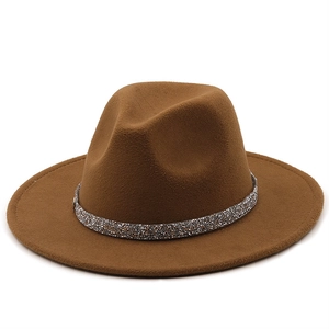 Détail d'un chapeau fedora marron en laine avec un ruban scintillant argenté