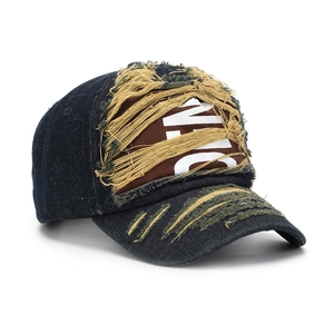 Detail of distressed navy denim baseball cap with NYC embroidery and frayed ripped edges