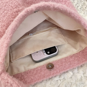 Détail de l'intérieur du sac en peluche rose avec poche zippée et fermoir magnétique