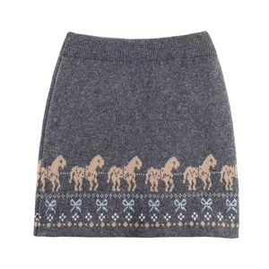 Detail of dark grey knit skirt featuring beige horse and blue bow jacquard patterns
