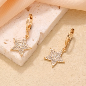 Close-up of star-shaped earrings with gold plating and cubic zirconia micro-pave setting