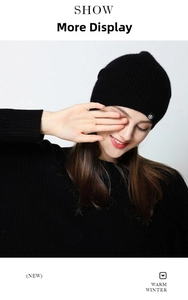 Vista detallada del gorro de punto de lana negra con un pequeño logo metálico lateral