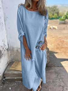 Detail of light blue dress showing metal buckle decoration and cotton linen fabric texture
