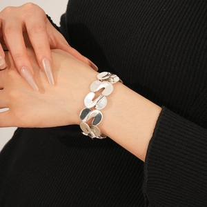 Detail of silver S-shaped metal link bracelet worn on wrist with polished finish