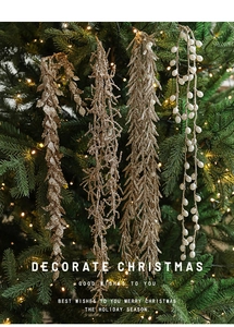 Close-up of golden glitter leaves, beaded strands and branched holiday ornaments