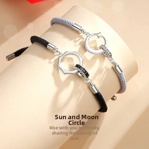 Close-up of Sun and Moon charm braided couple bracelets with silver metal accents