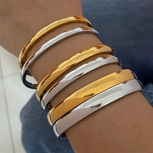 Minimalist stackable titanium steel bangles in polished gold and silver finishes