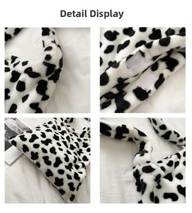 Detail of faux fur cow print shoulder bag showing wide strap and velcro closure system