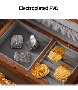 Detail showing gold and silver square textured rings in a velvet jewelry box
