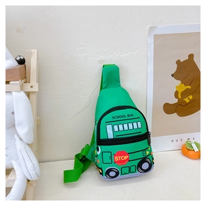 Detail of green school bus shaped kids chest bag with adjustable strap on white table