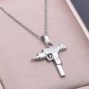 Macro shot of silver Uzi gun pendant on a fine chain inside a champagne jewelry box