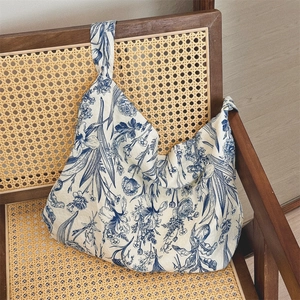 Detail of blue floral cotton tote bag texture on a vintage rattan chair