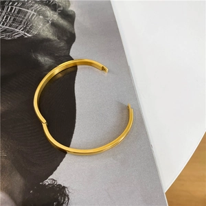 Detailed close-up of 18K gold-plated stainless steel bangle with functional hinge clasp