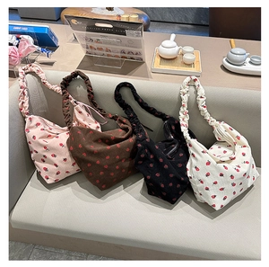 Detail view of corduroy hobo bags in four colors with red strawberry patterns and ruched straps