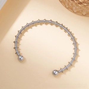 Detailed view of silver titanium steel spiral twisted open bangle with polished metal beads