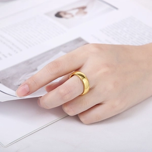 Bague minimaliste de 6mm en acier inoxydable doré portée par un mannequin chic