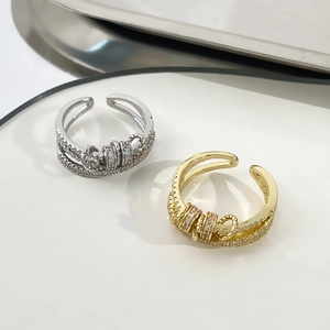 Adjustable multilayer zircon spinner rings in gold and silver finish on white ceramic