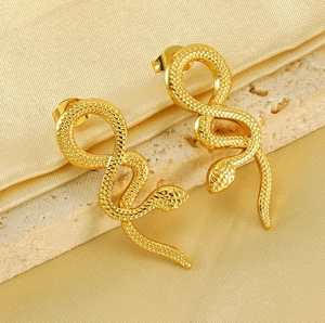 Detailed close-up of golden snake stud earrings with realistic scale texture on silk