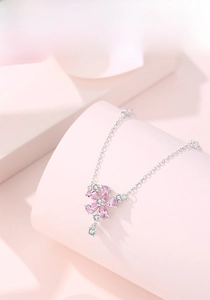 Close-up of peach blossom pendant with pink pear-cut crystals and silver chain detail