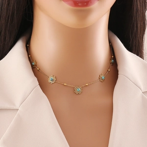 Vintage gold stainless steel necklace with turquoise flower pendants worn by a model