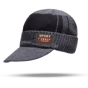 Detail of gray knitted peaked cap with leather sport patch and ribbed texture