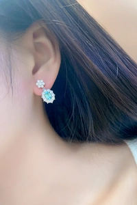 Close-up of mint green Paraiba gemstone drop earrings with white diamond halo