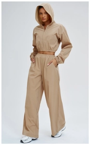 Detail of khaki windproof hooded jacket and wide-leg sports pants with elastic hem