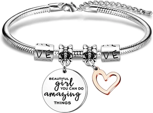Macro shot of silver charm bracelet with engraved motivational phrase on round pendant