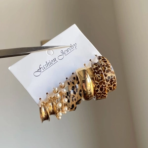Fashion Jewelry set featuring six pairs of gold metal, pearl, and leopard resin hoop earrings