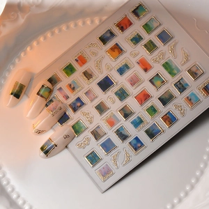 Macro view of vintage oil painting nail stickers with gold embossed frames on a tray