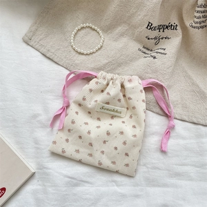 Detailed macro view of floral corduroy drawstring pouch with pink ribbon closure