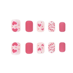 Unghie finte corte quadrate con motivi a cuore rosa e strisce zebrate per un look dolce