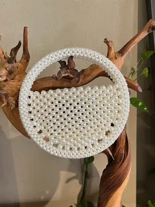 Elegant beaded pearl handbag with a semi-circle shape and integrated top handle