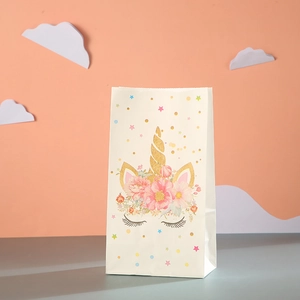 Detail of unicorn party gift bag with gold horn floral crown and glitter star patterns
