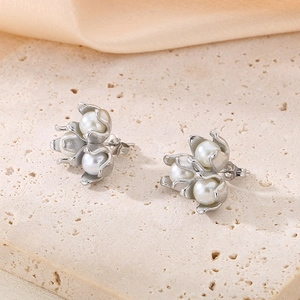 Detail of silver lily of the valley earrings with white pearls on elegant silk