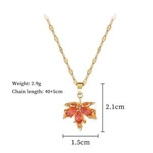 Detail view of gold maple leaf pendant with orange gemstone and product specifications