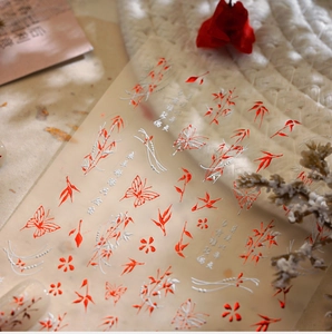 Detail of Chinese style nail stickers with red and silver bamboo leaves and floral patterns