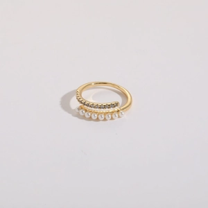 Macro shot of double-layered gold ring featuring tiny zircons and white freshwater pearls