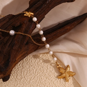 Detailed macro view of 18K gold plated starfish pendant with elegant white pearls