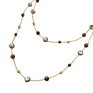 Collier plaqué or 18 carats avec pierres œil de tigre et perles sur fond blanc